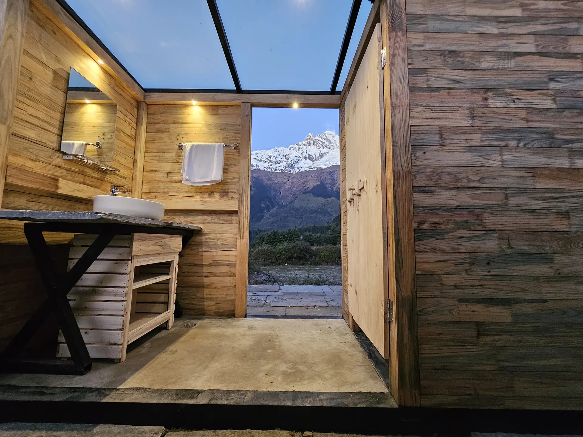 Timber cabin interior opening onto a mountain view